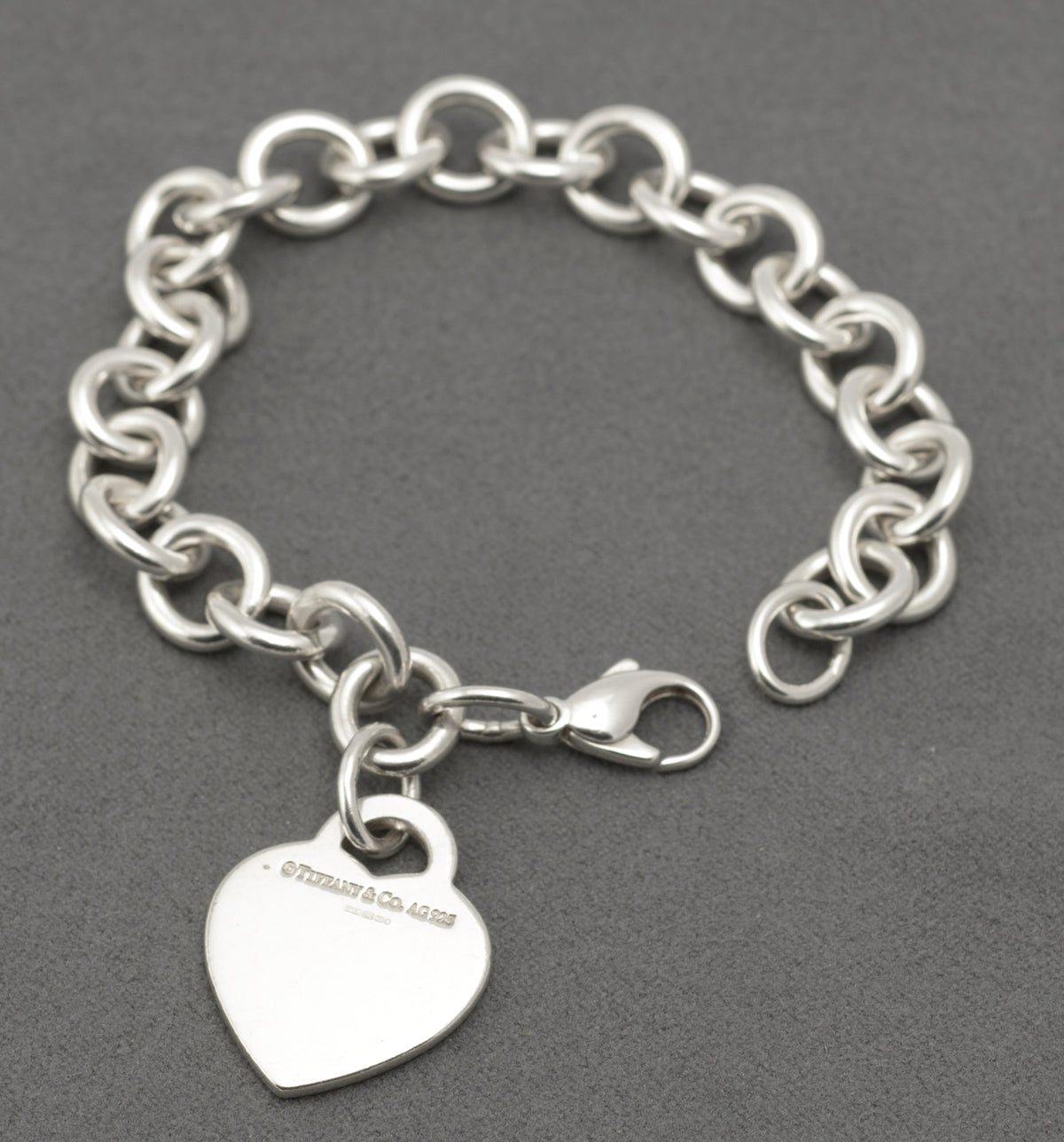 Tiffany sterling silver round link bracelet laid open with engraved heart tag and lobster clasp