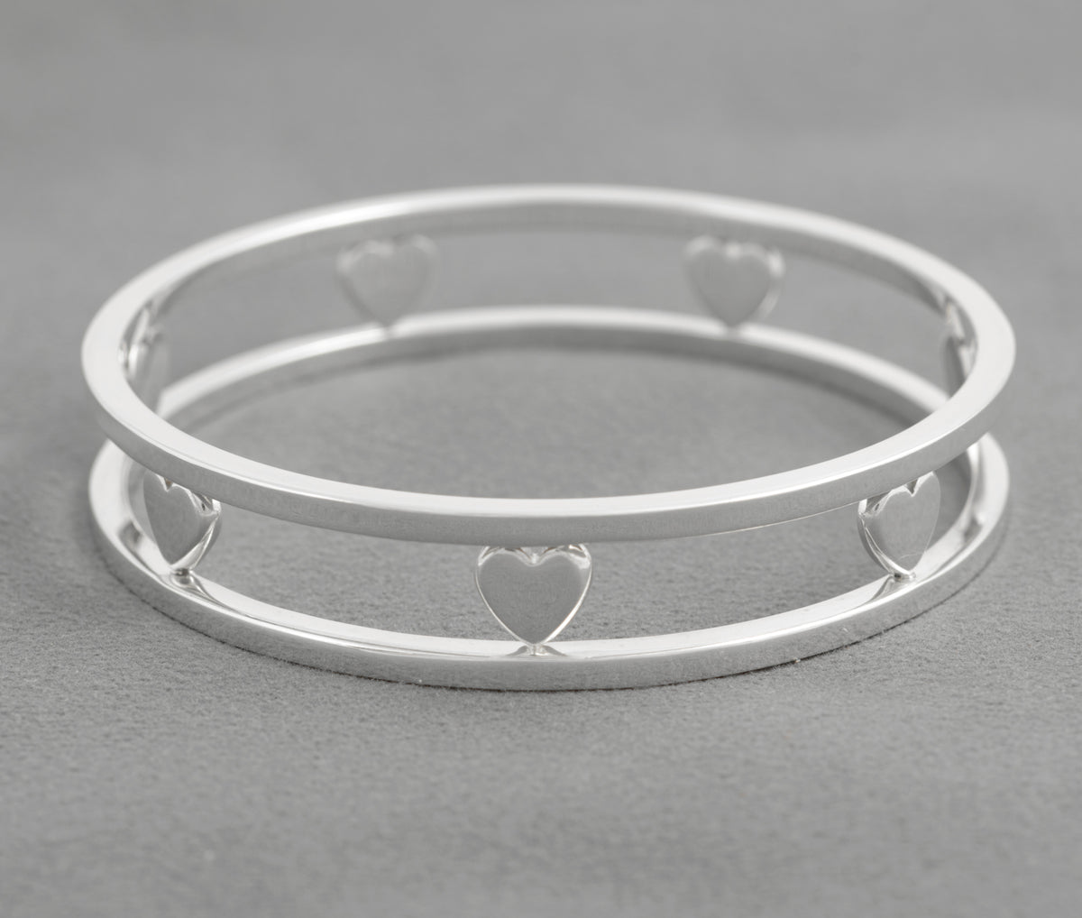 Tiffany Floating Heart silver bangle on grey background showing its open double rail construction