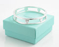 Sterling silver Tiffany Floating Heart bangle displayed on its presentation box