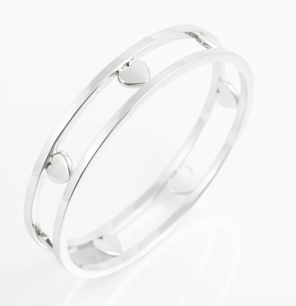 Angled view of Tiffany sterling silver Floating Heart bangle showing polished hearts between solid rails