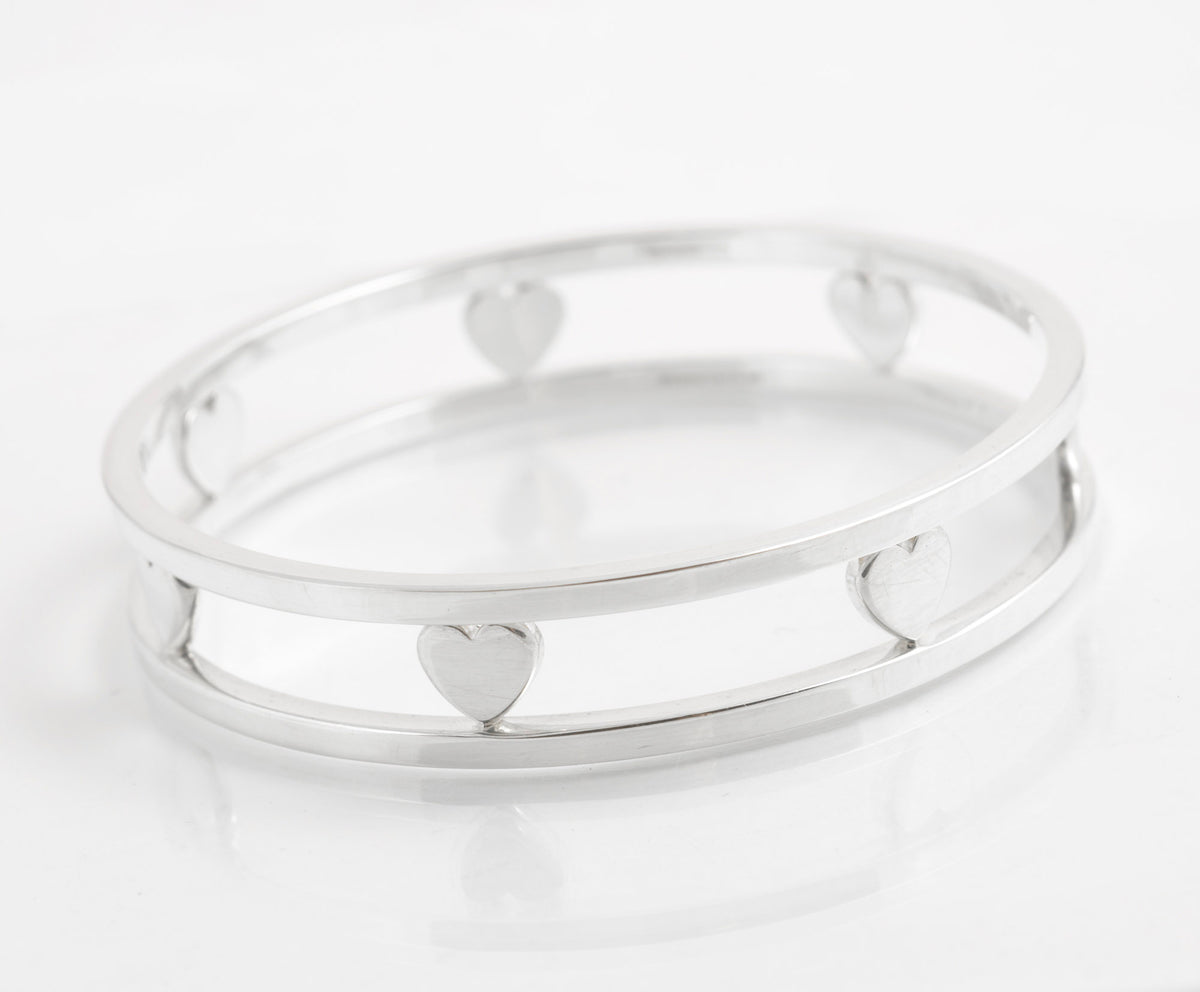 Side view of Tiffany sterling silver bangle showing hearts bridging two circular rails