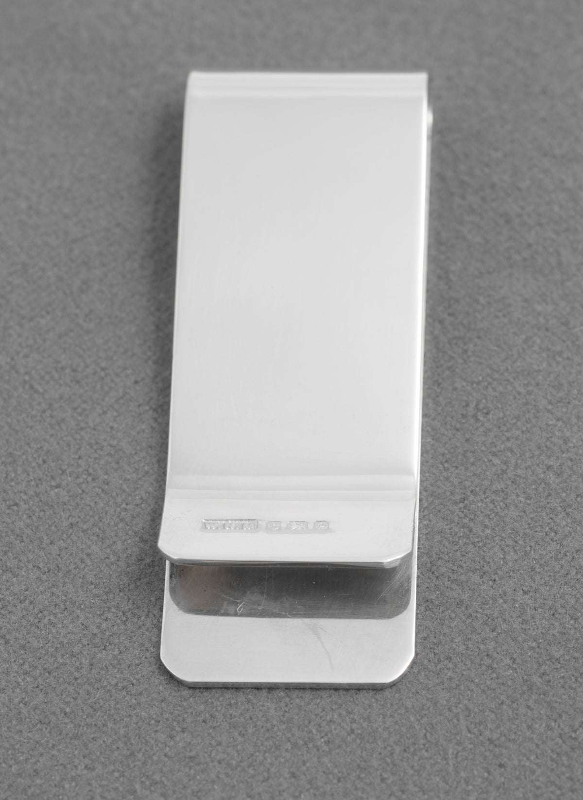 Silver money clip beside a British coin for scale