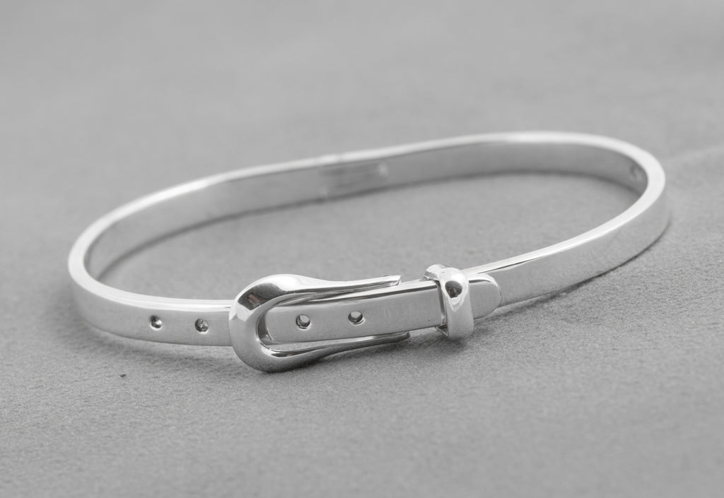 Angled view of the narrow sterling silver belt bangle with buckle closed