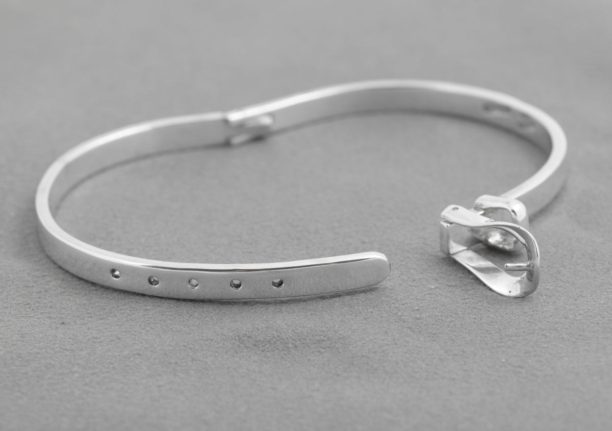 Close view of the open hinged buckle and five holes on the silver bangle