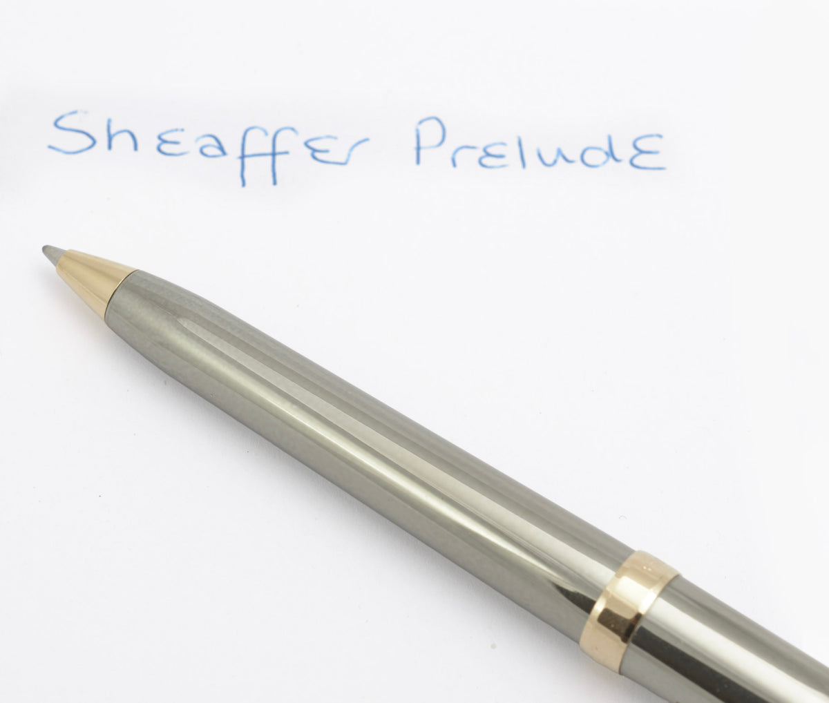 Sheaffer Prelude pen beside a blue ink writing sample