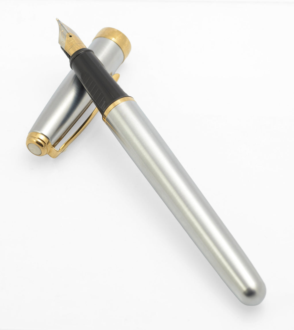 Uncapped Sheaffer Prelude fountain pen resting across its brushed chrome cap