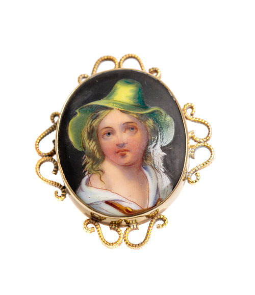 A 9ct gold brooch with a hand-painted porcelain portrait of a gypsy girl, featuring a green hat and a floral dress.